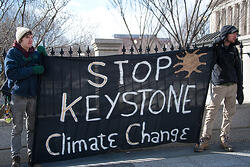 Protestors holding a sign that reads, Stop Keystone Climate Change