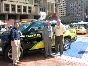 Two men standing in front of a flex fuel Chevy Avalanche