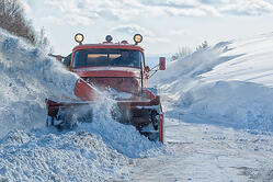 Snow plow plowing a snow covered road