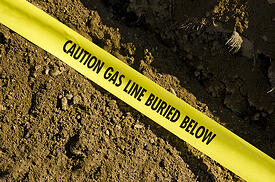 Yellow caution tape reading, caution gas line buried below