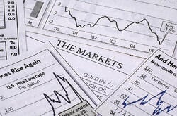 Line charts depicting the stock market scattered on a table