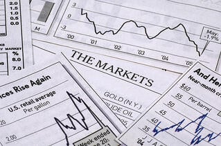 Line graphs depicting the stock market scattered over a table