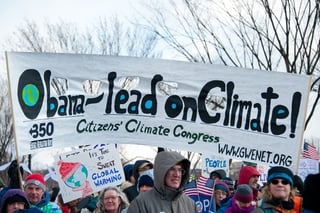 Protesters holding a sign the reads, Obama-lead onClimate