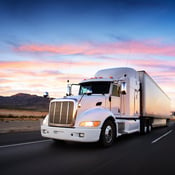 Semi-truck driving at dusk
