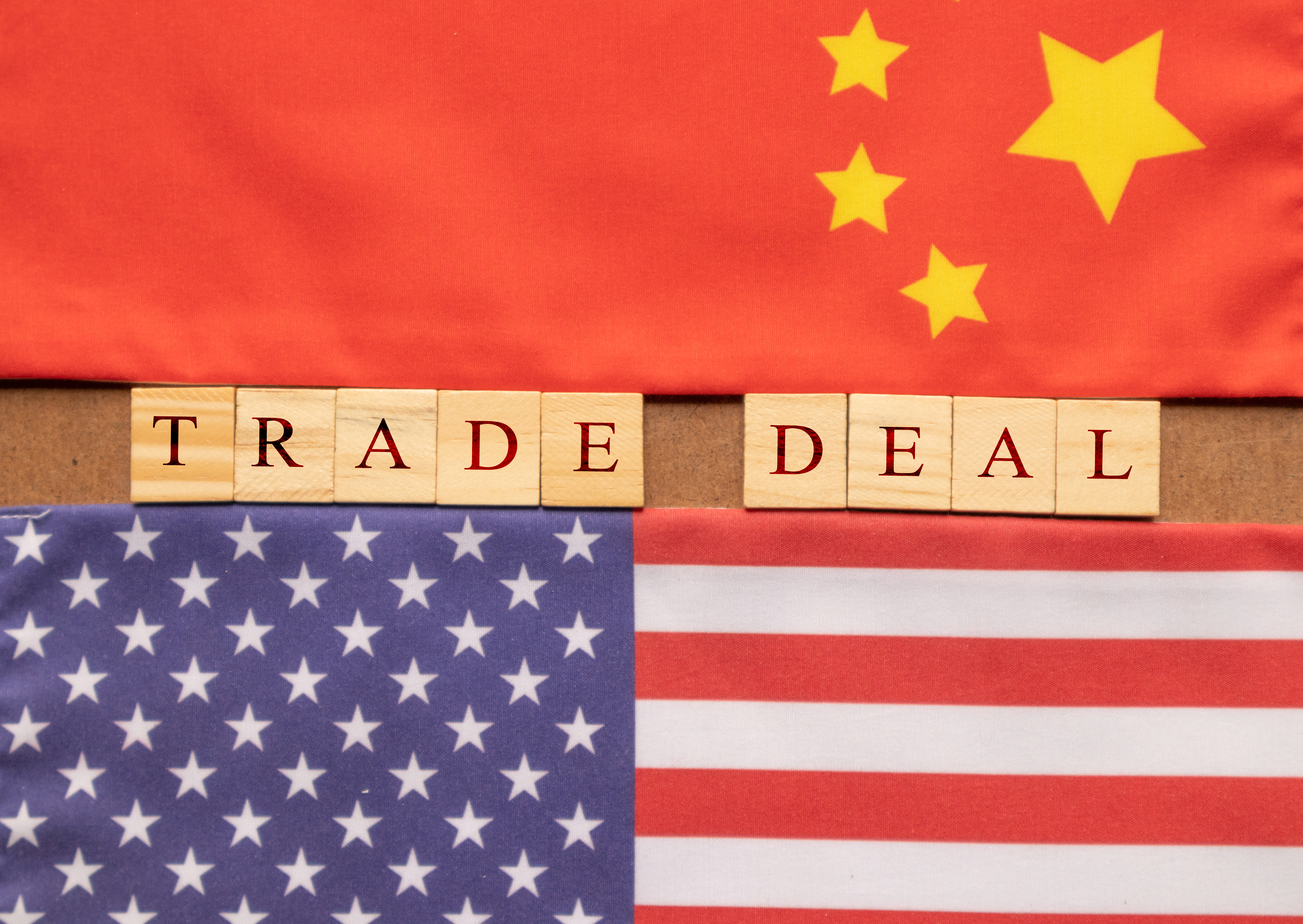 image of chinese and US flags with scrabble tiles spelling out trade deal 